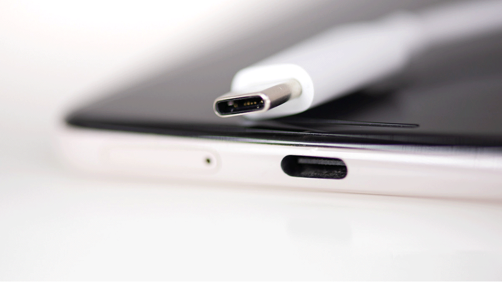Chargeurs et câbles USB-C posés sur un plan de travail d'atelier de réparation
