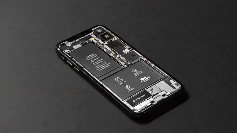 Smartphone ouvert laissant voir la batterie lithium-ion logée dans le châssis à côté de la carte mère