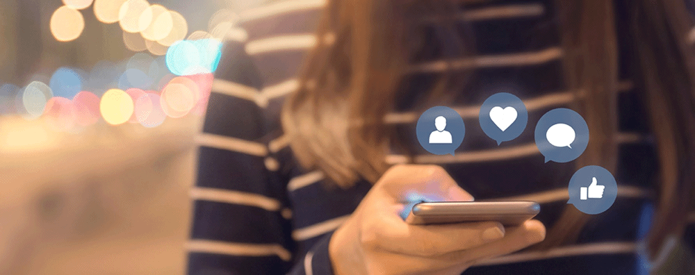 Utilisation des réseaux sociaux sur un smartphone tenu à deux mains